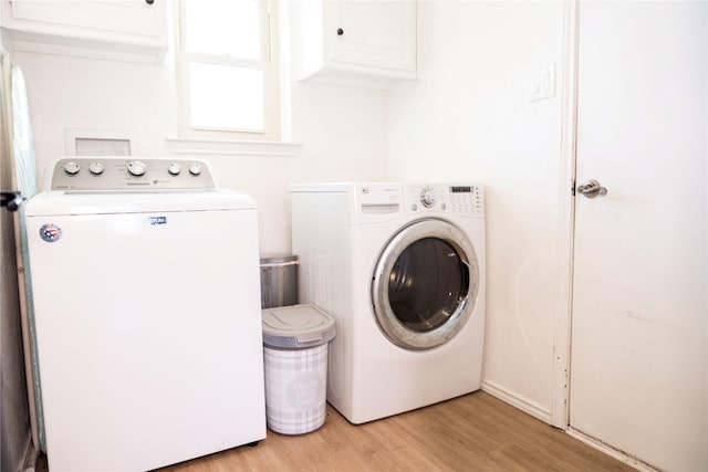 laundry area featuring cabinets, independent washer and dryer, and light wood-type flooring