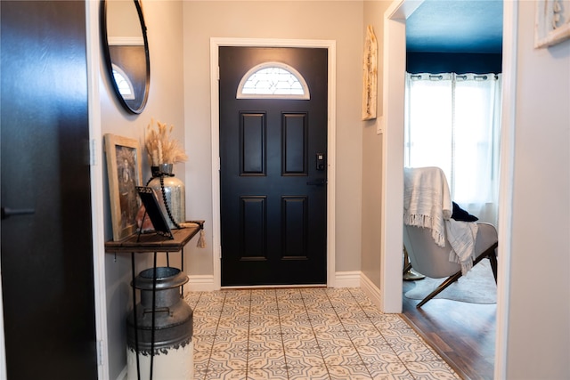 entrance foyer with light tile patterned floors and a wealth of natural light