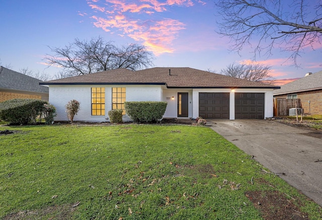 single story home with a garage and a yard