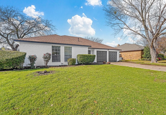 ranch-style home with a garage and a front lawn