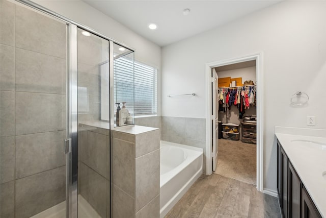 bathroom with vanity, hardwood / wood-style floors, and separate shower and tub