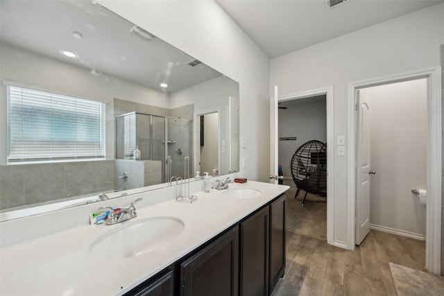 bathroom featuring wood-type flooring, vanity, and walk in shower