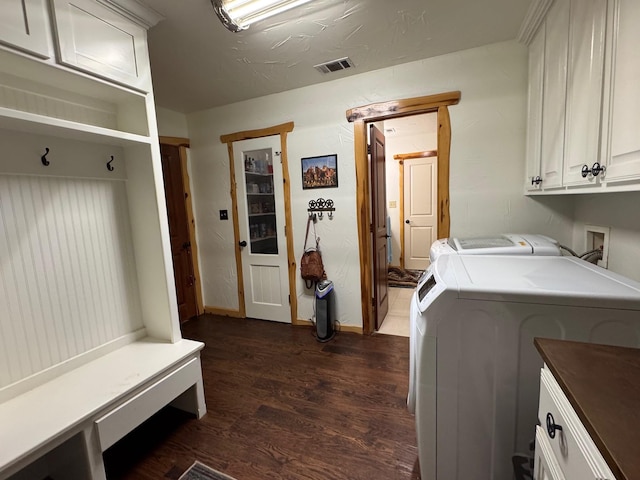 laundry room with dark wood-type flooring, cabinets, and washing machine and dryer