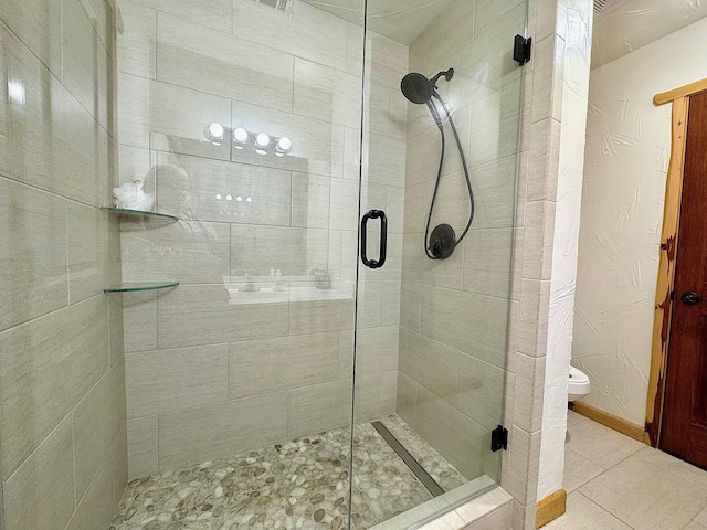 bathroom with walk in shower, tile patterned floors, and toilet