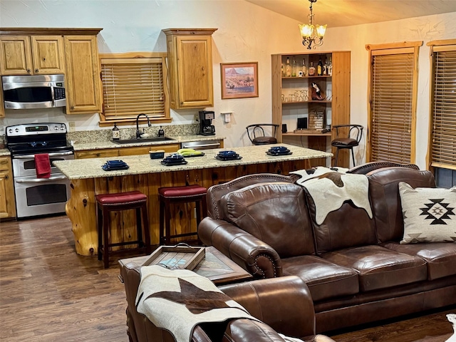 kitchen featuring light stone countertops, stainless steel appliances, hanging light fixtures, and a kitchen island