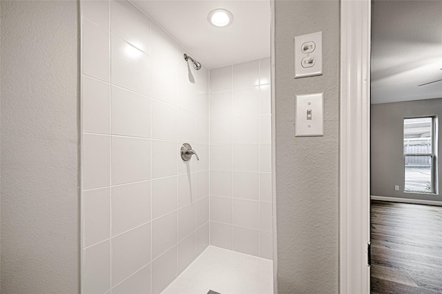 bathroom with hardwood / wood-style flooring and tiled shower