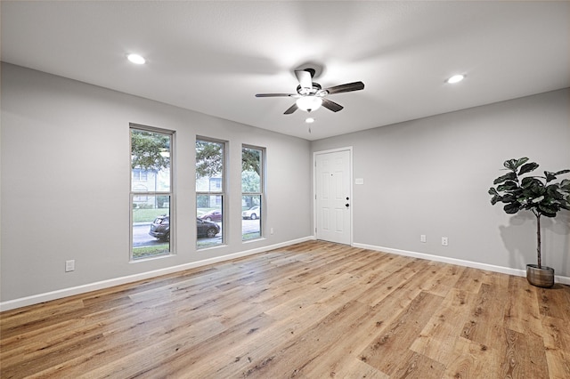 empty room with ceiling fan and light hardwood / wood-style floors