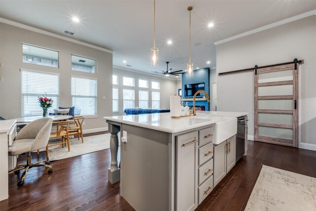 kitchen with hanging light fixtures, stainless steel appliances, a barn door, and white cabinets