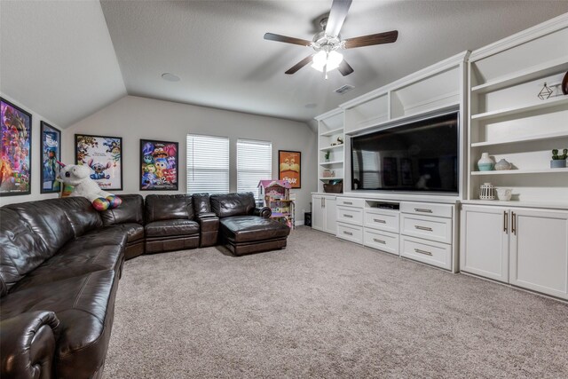 living room with ceiling fan, vaulted ceiling, light colored carpet, and a textured ceiling