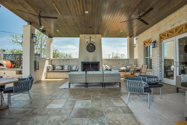 view of patio / terrace featuring ceiling fan and an outdoor living space with a fireplace