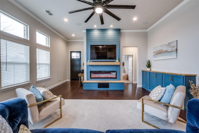 living room featuring crown molding, dark hardwood / wood-style floors, ceiling fan, and a fireplace