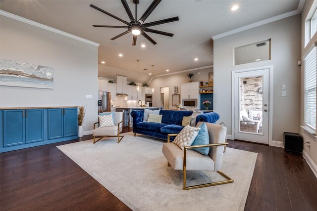 living room with a towering ceiling, dark wood-type flooring, ornamental molding, and ceiling fan