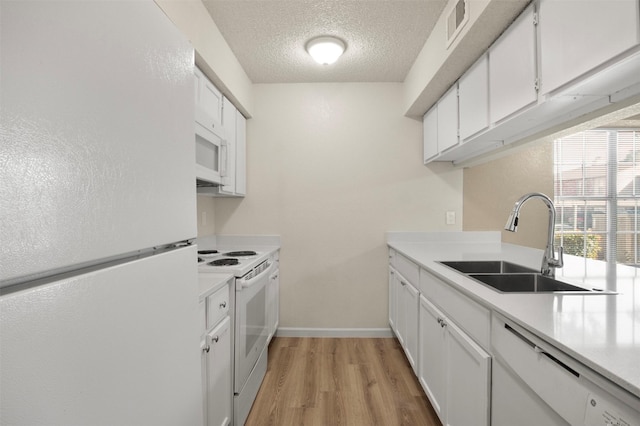 kitchen featuring white cabinetry, sink, white appliances, light hardwood / wood-style floors, and a textured ceiling