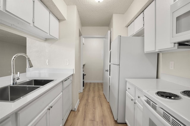 kitchen with sink, light hardwood / wood-style flooring, a textured ceiling, white appliances, and white cabinets