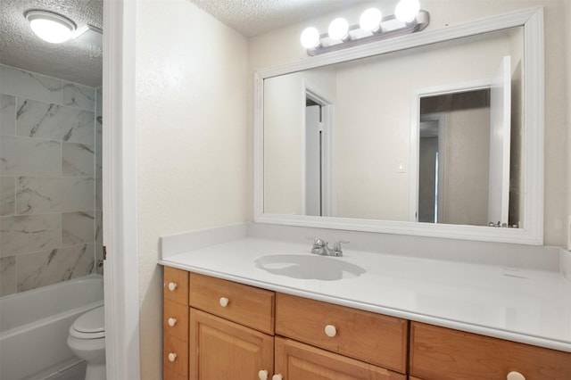 full bathroom featuring tiled shower / bath, vanity, toilet, and a textured ceiling