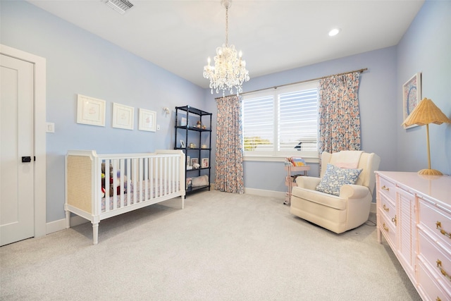 carpeted bedroom featuring a crib and a chandelier