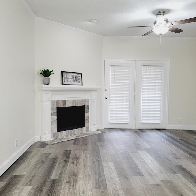 unfurnished living room featuring a tiled fireplace, crown molding, and light hardwood / wood-style floors