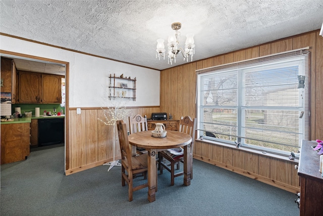 dining area with dark colored carpet, plenty of natural light, a notable chandelier, and wood walls