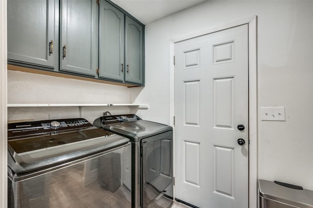 washroom with cabinets and washing machine and dryer