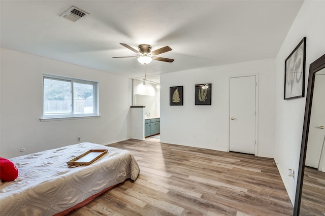 bedroom with wood-type flooring, connected bathroom, and ceiling fan