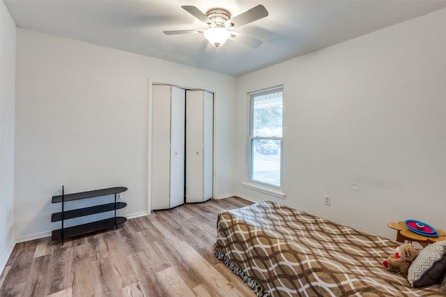 bedroom with light hardwood / wood-style flooring, a closet, and ceiling fan