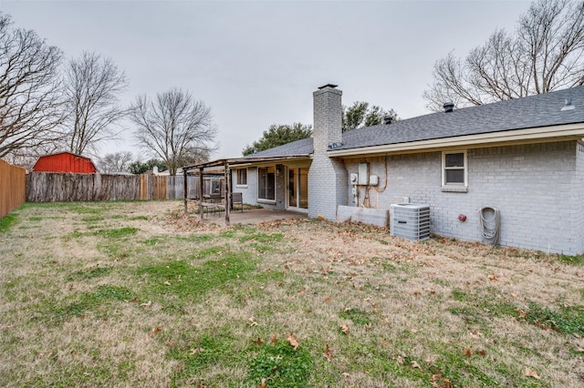 rear view of property featuring a yard, a patio area, and central air condition unit