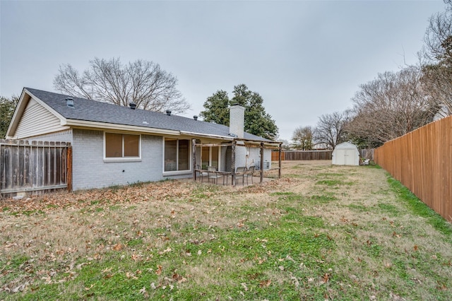 back of house featuring a yard and a shed