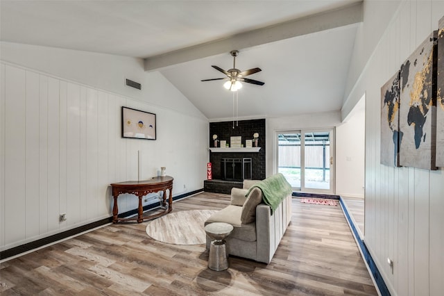 living room with hardwood / wood-style flooring, a fireplace, lofted ceiling with beams, and ceiling fan