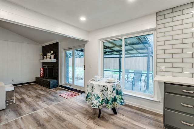 interior space with hardwood / wood-style flooring, vaulted ceiling, and a fireplace