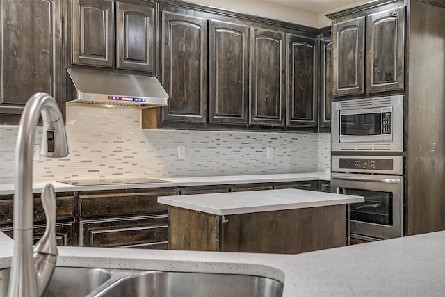 kitchen featuring stainless steel appliances, dark brown cabinets, and exhaust hood