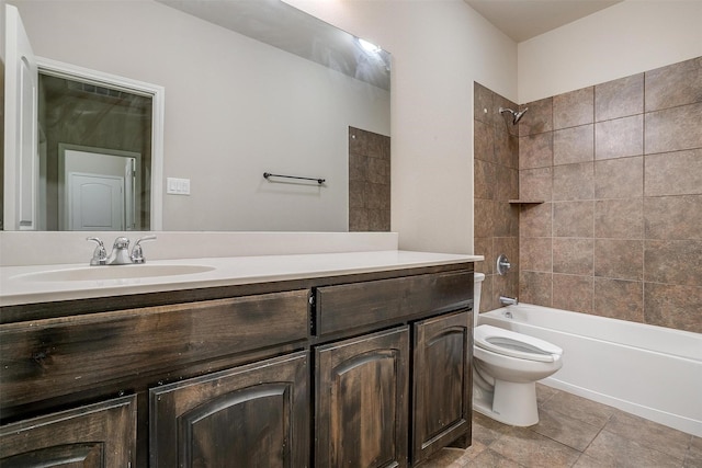 full bathroom featuring tiled shower / bath, vanity, toilet, and tile patterned floors