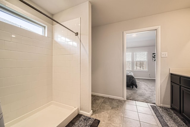 bathroom with vanity, a tile shower, and tile patterned floors