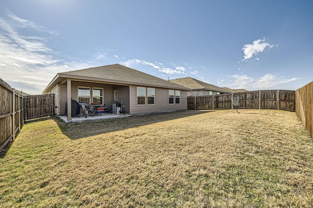 back of house with a yard and a patio