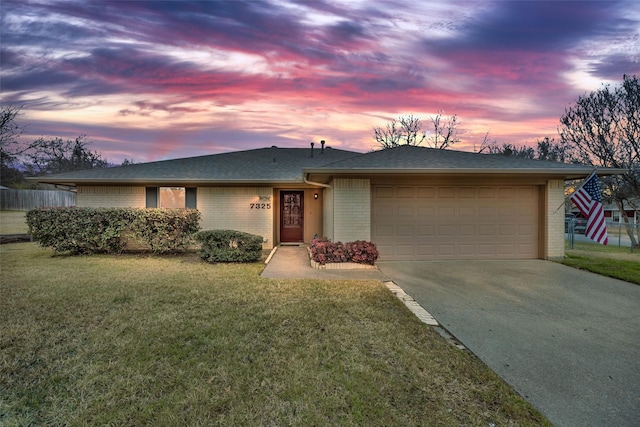 ranch-style home with a garage and a lawn