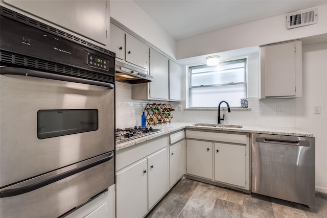 kitchen with white cabinetry, sink, decorative backsplash, and stainless steel appliances