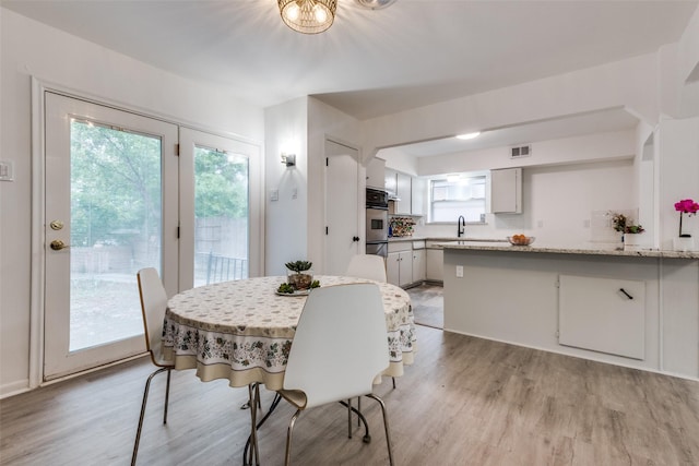 dining area featuring sink and light hardwood / wood-style floors