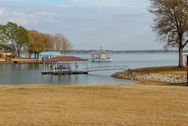 view of dock featuring a water view and a yard