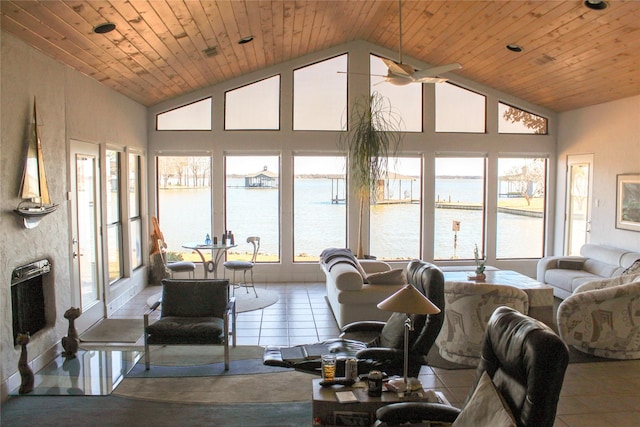 tiled living room featuring heating unit, wood ceiling, high vaulted ceiling, and a water view