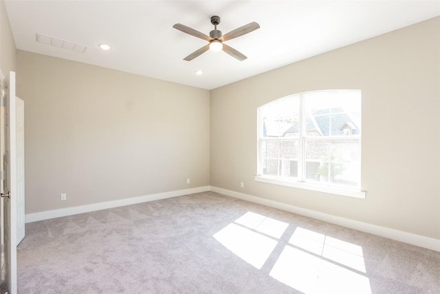 carpeted spare room featuring ceiling fan