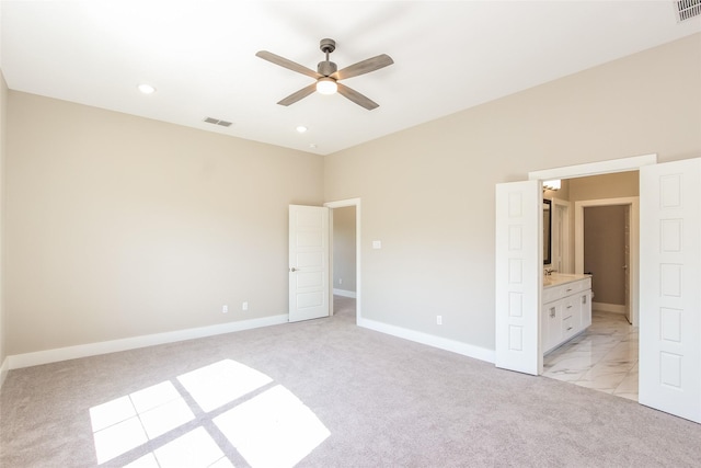 unfurnished bedroom with light colored carpet and connected bathroom