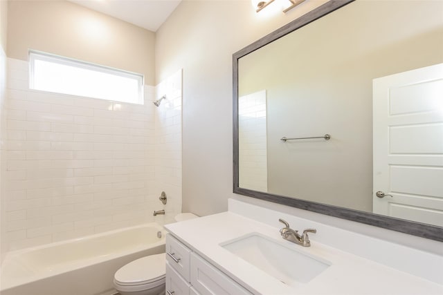 full bathroom with tiled shower / bath, vanity, and toilet