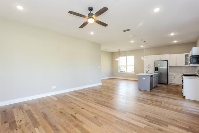 kitchen with a kitchen island, pendant lighting, sink, light hardwood / wood-style floors, and stainless steel fridge with ice dispenser