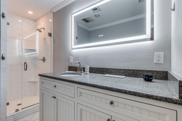 bathroom featuring vanity, a shower with door, and ornamental molding