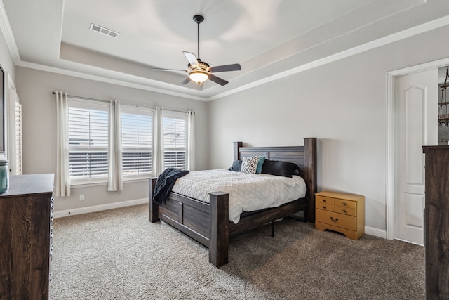 carpeted bedroom with a raised ceiling, crown molding, and ceiling fan