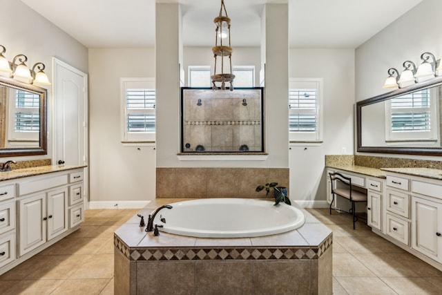 bathroom featuring tile patterned flooring, vanity, and a relaxing tiled tub