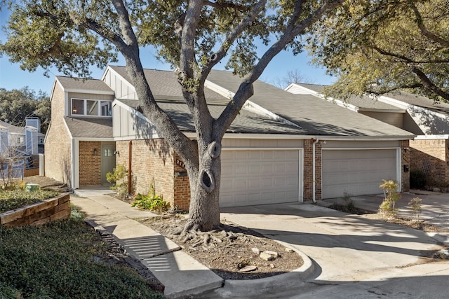 view of front facade with concrete driveway, a garage, brick siding, and roof with shingles