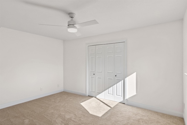 spare room with light colored carpet and ceiling fan