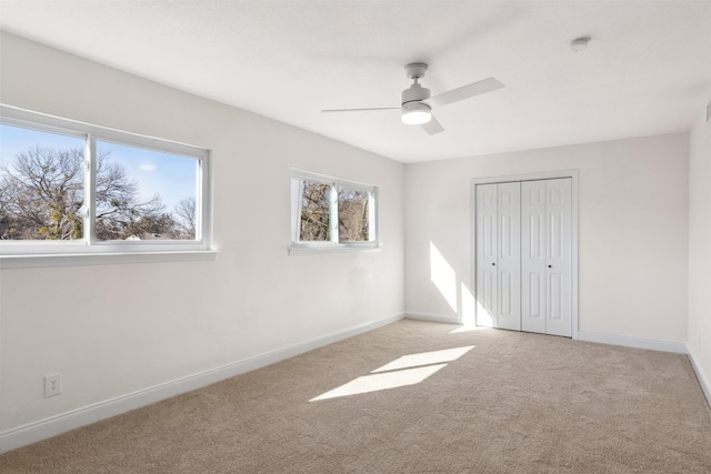 unfurnished bedroom with light colored carpet, ceiling fan, and a closet