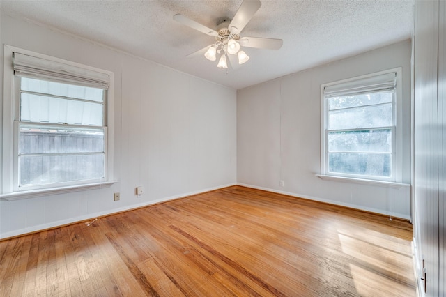 spare room with ceiling fan, a textured ceiling, and light wood-type flooring