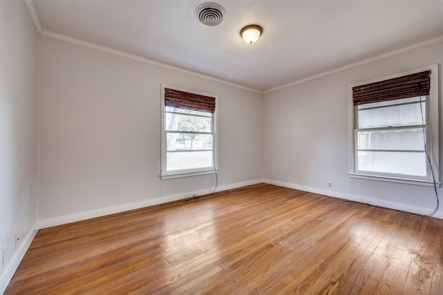 empty room with crown molding and light wood-type flooring